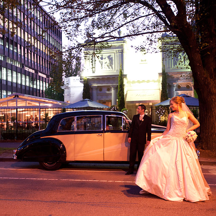 Wedding Photography Melbourne- a bride with an Aemstrong Siddeley Limousine crosses St Kilda Road, outside the Willows Restaurant.