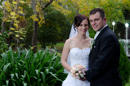 A wedding photo of newlyweds at Bram Leigh Croydon, showing the water feature